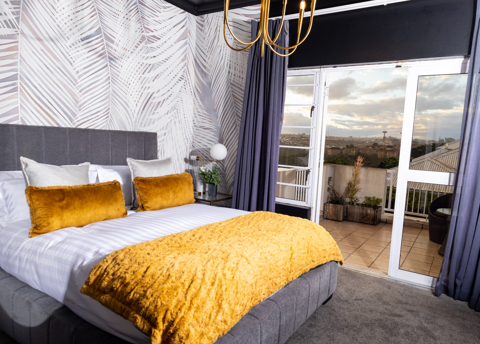 Gold-accented bedroom with balcony views at 14 Coralwood Villa in East London