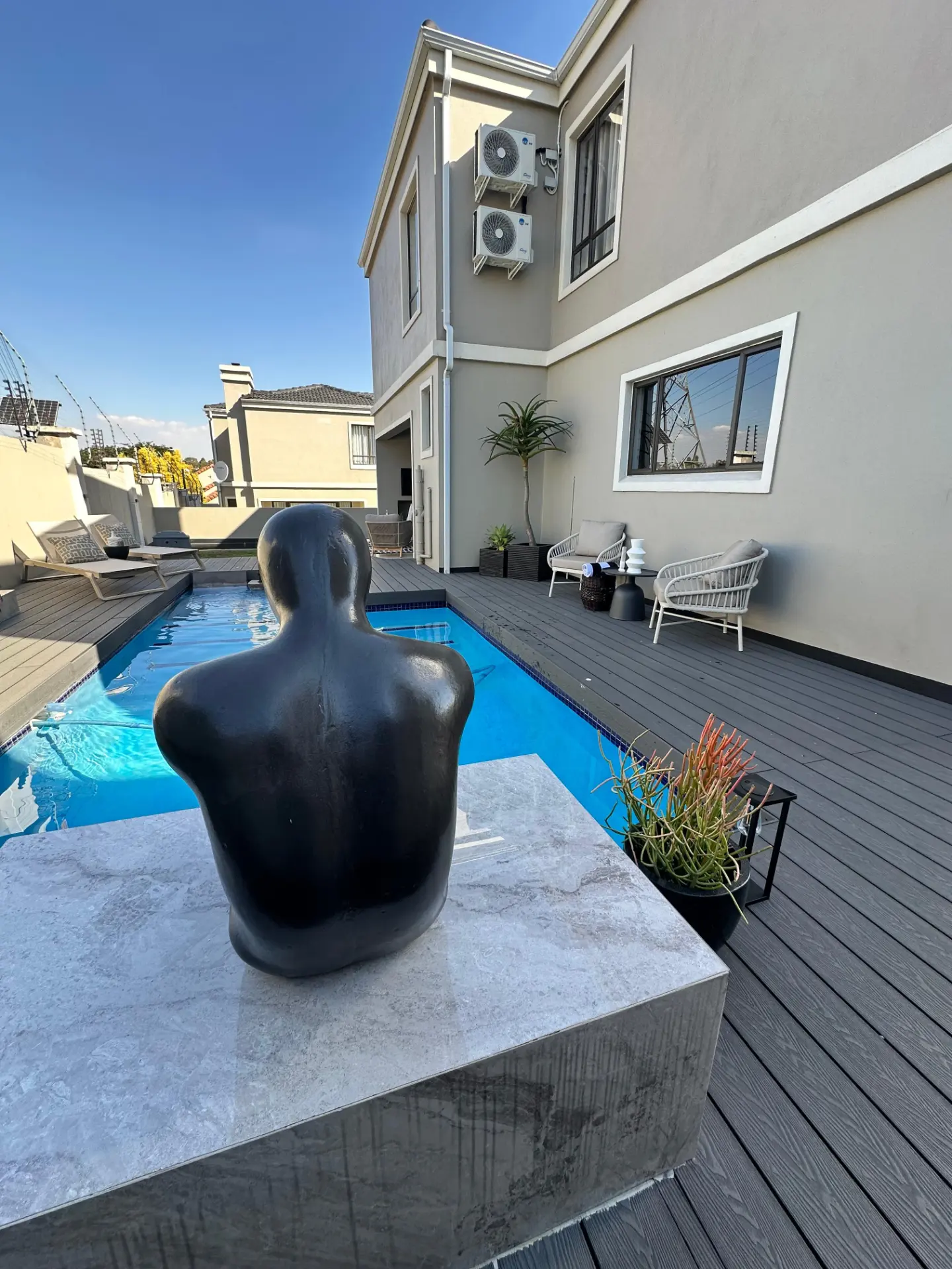 Sun-drenched pool deck with a sculptural figure at 34 Mont Trenblant